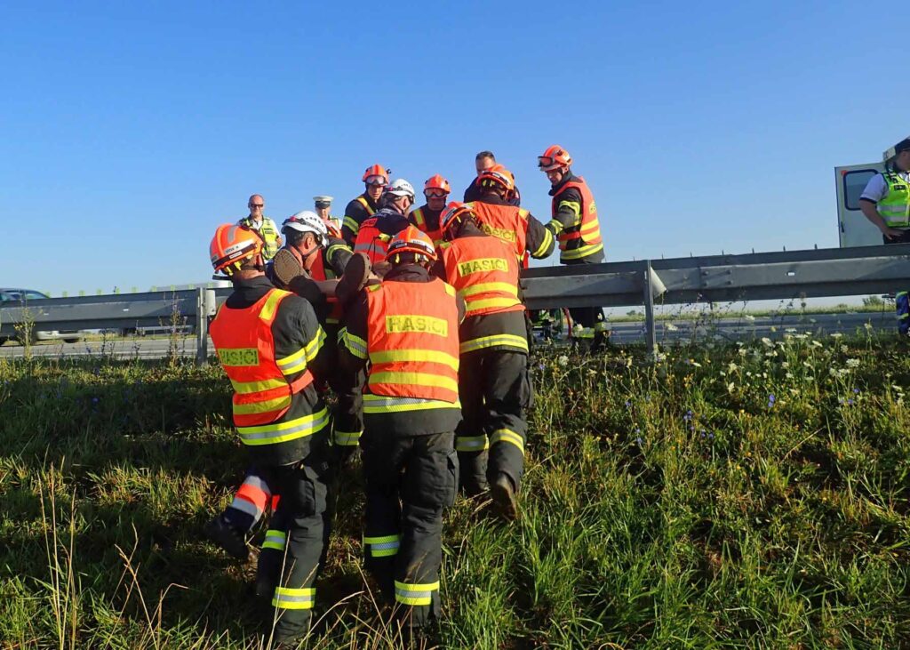 Hasiči řidiče vyprostili z auta a přenesli terénem na dálnici ke zdravotníkům. Foto: HZS