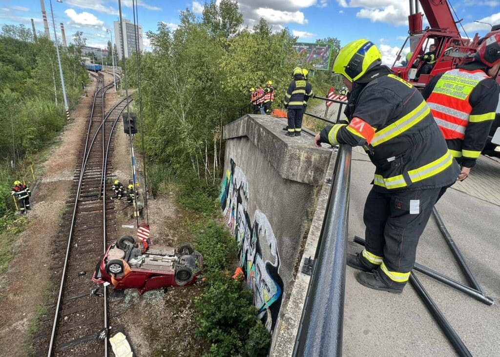 Auto v Černokostelecké ulici v Praze vyletělo z mostu a zřítilo se na koleje. Foto: HZS Praha