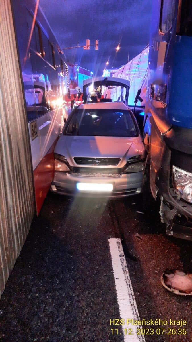 Autobus a kamion v Plzni mezi sebe přimáčkli osobní auto Opel. Foto: HZS