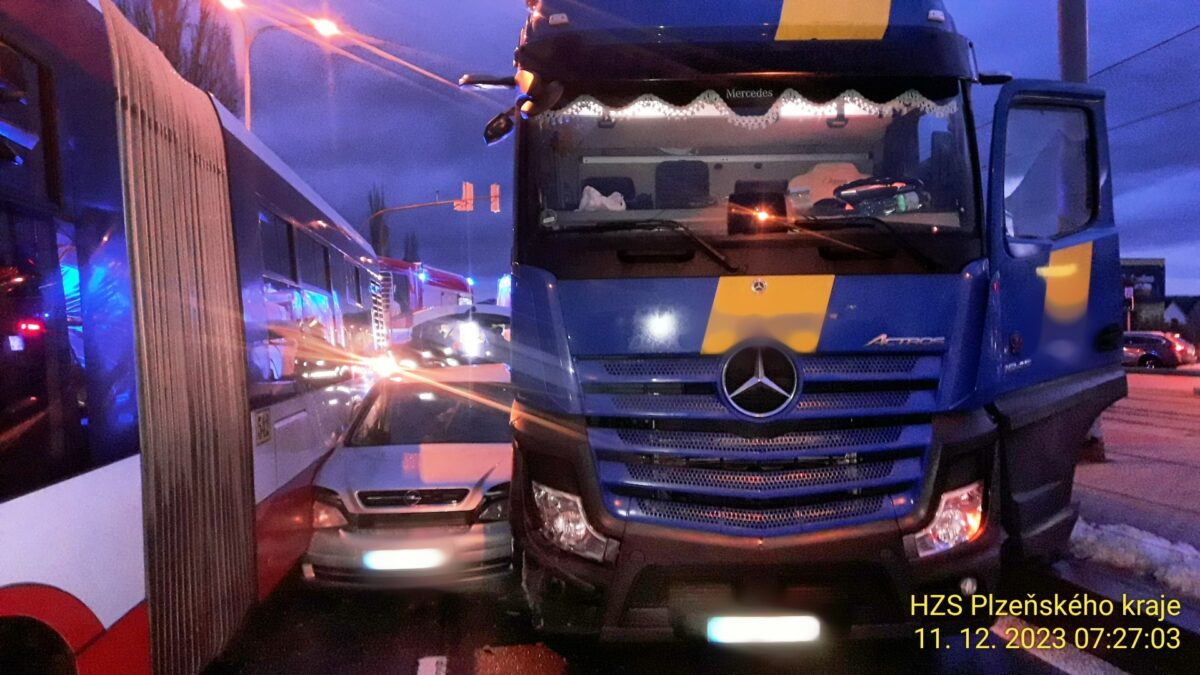 Autobus a kamion v Plzni mezi sebe přimáčkli osobní auto Opel. Foto: HZS