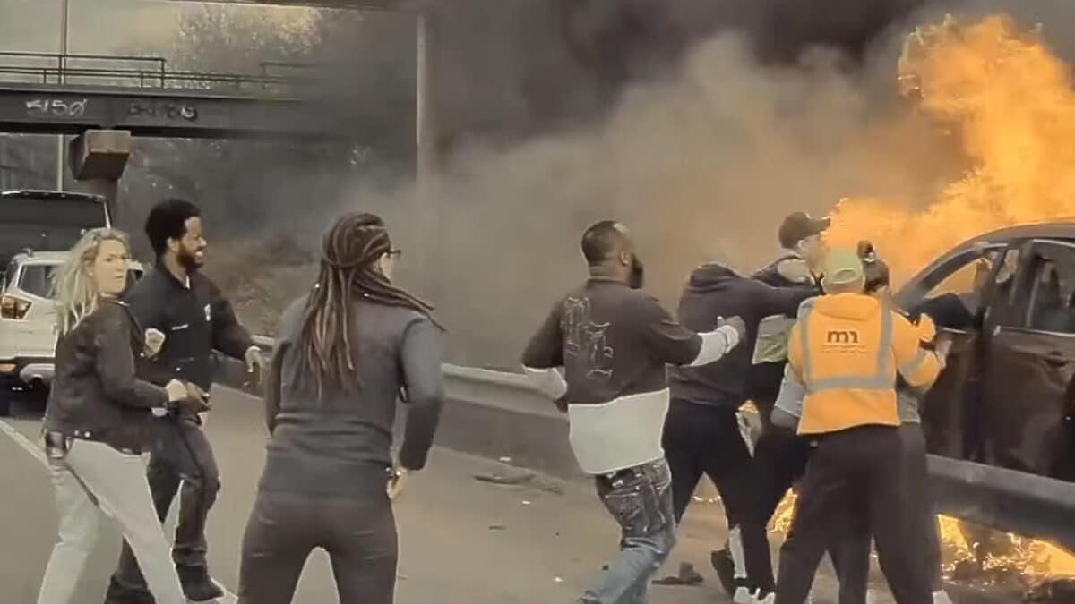 Lidé se snaží zachránit řidiče z hořícího auta po nehodě na dálnici. Zdroj: FB/Kadir Tolla