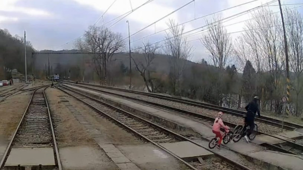 Cyklista s dítětem přechází koleje v Zadní Třebani. Zdroj: IG jarynjarin
