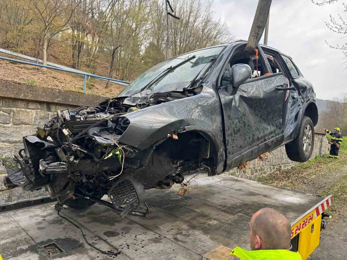 Zdemolovaný vůz pak vytáhli ze svahu a naložili na odtahovku. Foto: HZS