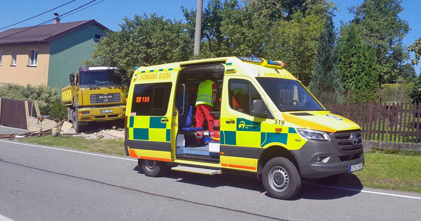 Řidič náklaďáku zkolaboval a vůz pak zbořil plot. Foto: ZZS