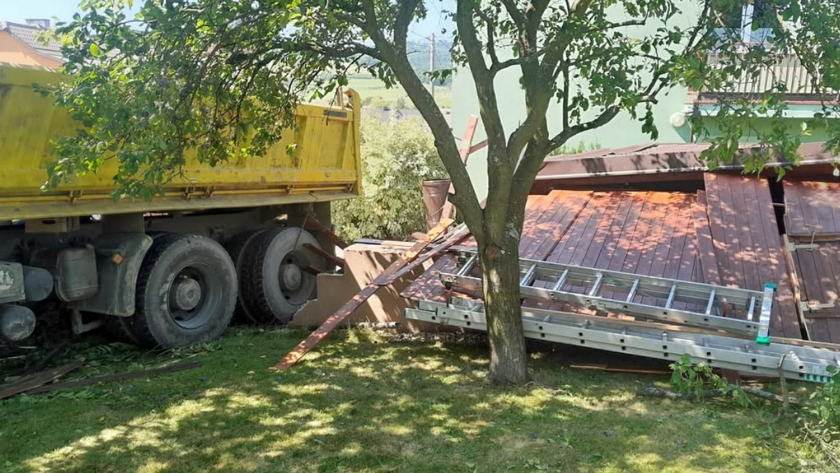 Řidič náklaďáku zkolaboval a vůz pak zbořil plot. Foto: ZZS