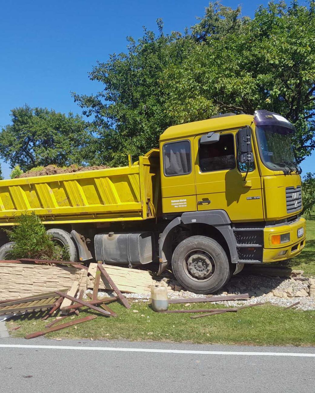 Řidič náklaďáku zkolaboval a vůz pak zbořil plot. Foto: ZZS